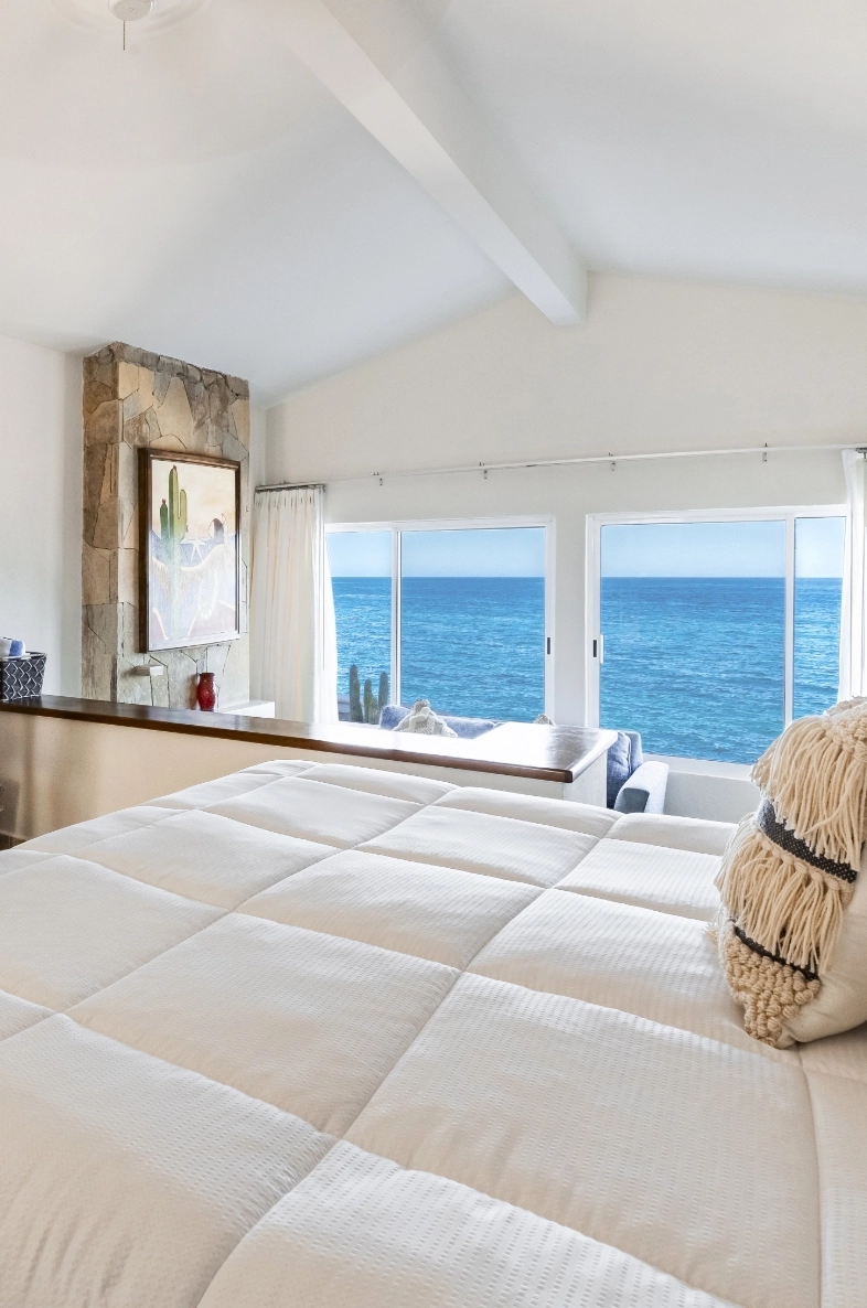 Villas 2 a bedroom with a large bed and a large window overlooking the ocean